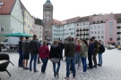 Mehrere Personen auf Platz in Landsberg, im Hintergrund Schmalzturm