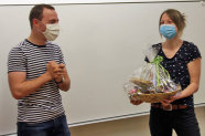 Mann und Frau  mit Mund-Nasen-Maske; Frau hält Geschenkkorb
