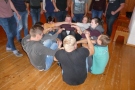 Schüler sitzen im Kreis und halten sich gegenseitig an den Händen
