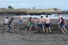 Studierende spielen Fußball am Strand