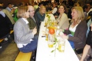 Personen sitzen an Tisch zusammen