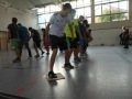 Mehrere Personen gehen auf Stofftüchern durch Turnhalle