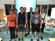 Sieben Personen vor Leinwand