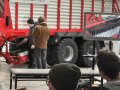 2 Personen stehen neben Hinterrädern eines Ladewagens