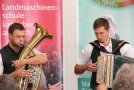 Mann bläst in Tenorhorn, anderer Mann spielt Akkordeon