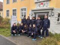 Personengruppe vor einem gelben Gebäude