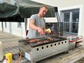Person steht hinter Grill