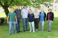 7 Personen stehen auf einer Wiese nebeneinander