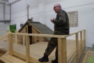 und vor dem Nachbau einer Erdhütte, in denen die KZ-Häftlinge unter unmenschlichen Bedingungen eingepfercht wurden