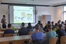 Mann steht neben Leinwand und spricht zu Studierenden