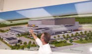 Mann zeigt auf Poster mit Logistikzentrum